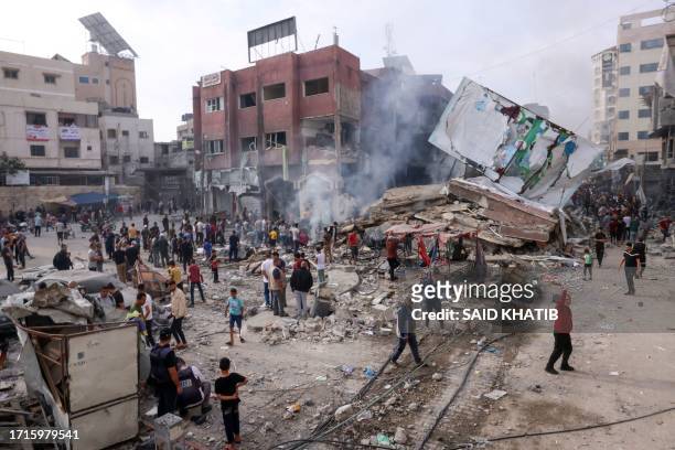 Palestinians inspect the rubble of a collapsed building in the heavily bombarded city center of Khan Yunis in the southern Gaza Strip following...