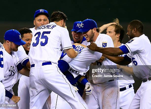 Teammates pull the shirt over the head of Alex Gordon of the Kansas City Royals after Gordon delivered the game-winning hit in the 10th inning of the...