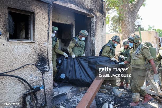 Israeli soldiers remove the body of a compatriot, killed during an attack by the Palestinian militants, in Kfar Aza, south of Israel bordering Gaza...