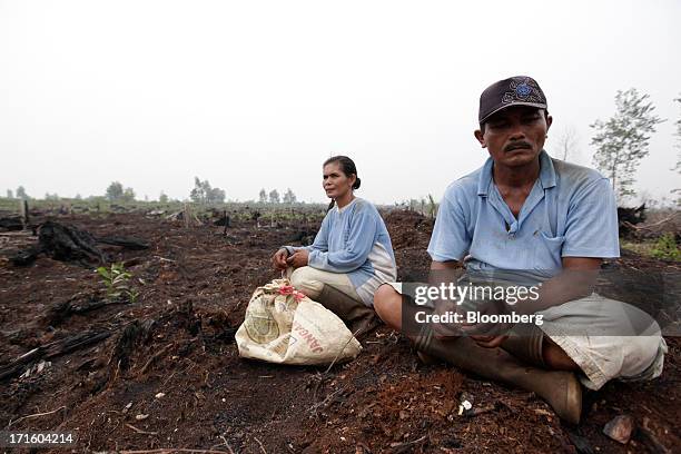 Villagers rest after planting trees in a damaged forest area in Plinting, Riau Province, Indonesia on Wednesday, June 26, 2013. Indonesia is open to...