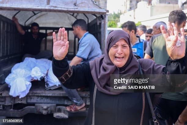 Palestinian woman reacts as bodies of people killed in overnight Israeli shelling arrive for their funeral in Khan Yunis in the southern Gaza Strip,...
