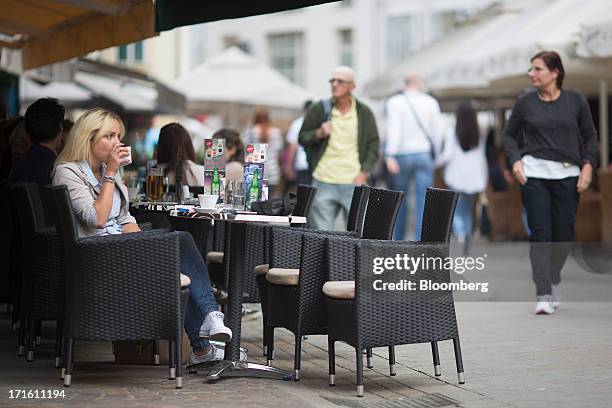 People are seen at local cafe's as pedestrians walk past in Zagreb, Croatia, on Wednesday, June 26, 2013. Croatia will become the EU's 28th member...