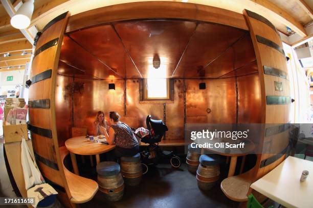 Members of the public sit in converted beer fermentation vessels in Adnams' cafe on June 25, 2013 in Southwold, England. Established in the small...