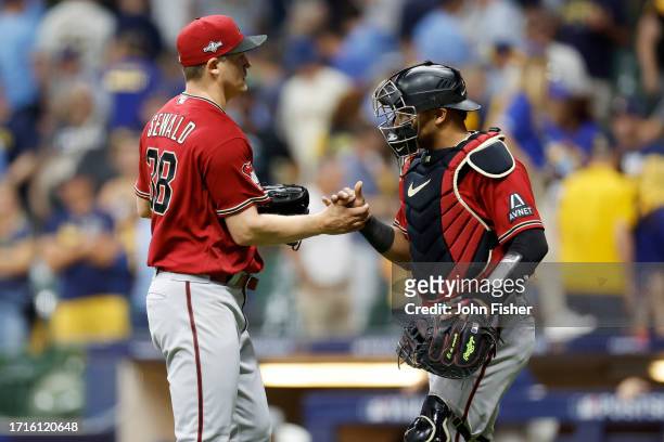 Gabriel Moreno and Paul Sewald of the Arizona Diamondbacks celebrate defeating the Milwaukee Brewers 6-3 during Game One of the Wild Card Series at...