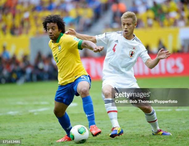 Marcelo of Brazil is challenged by Keisuke Honda of Japan during the FIFA Confederations Cup Brazil 2013 Group A match between Brazil and Japan at...