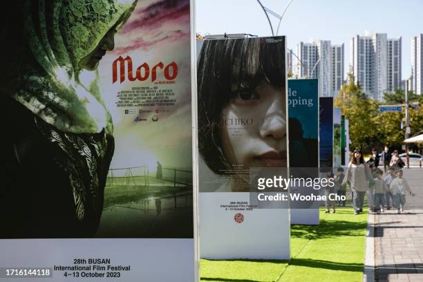 People walk by the movie poster walls during the 28th Busan International Film Festival at Busan Cinema Center on October 04, 2023 in Busan, South...