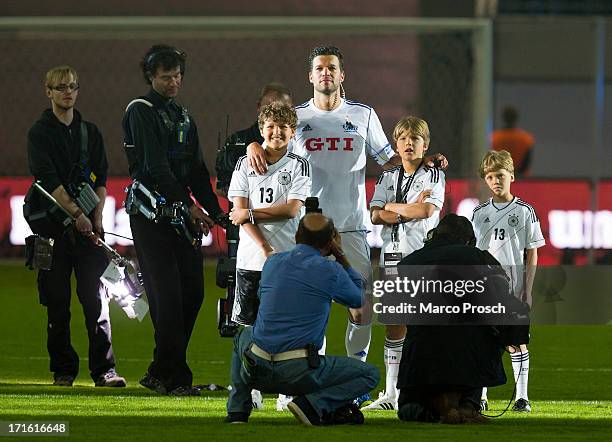 Michael Ballack and his three sons stand on the pitch after the Michael Ballack farewell match 'Ciao Capitano' at the Red Bull Arena on June 5, 2013...