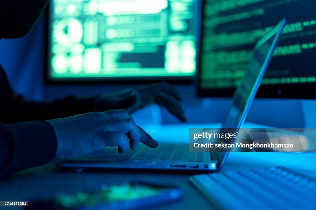 Hacker using laptop. Lots of digits on the computer screen.