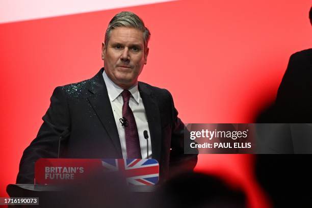 Britain's main opposition Labour Party leader Keir Starmer reacts after a protester threw glitter on him at the start of his keynote address to...