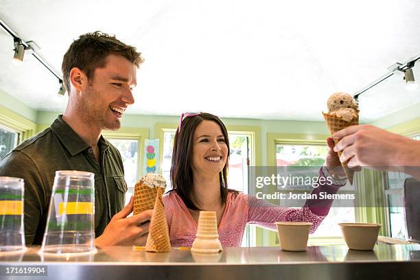 a couple enjoying a scoop of ice cream. - eiscreme kaufen stock-fotos und bilder