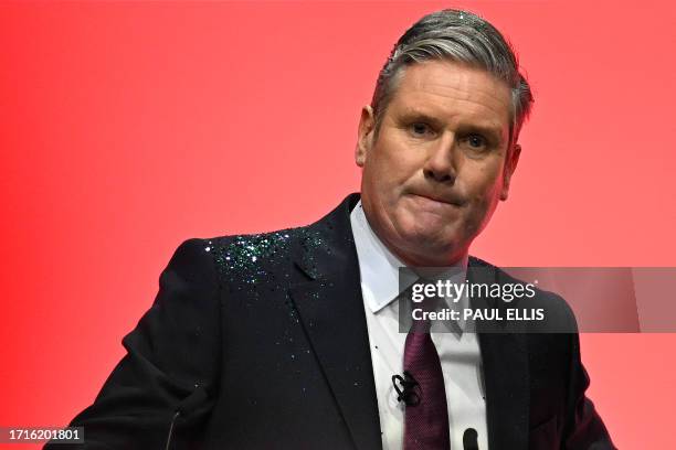 Britain's main opposition Labour Party leader Keir Starmer reacts after a protester threw glitter on him at the start of his keynote address to...