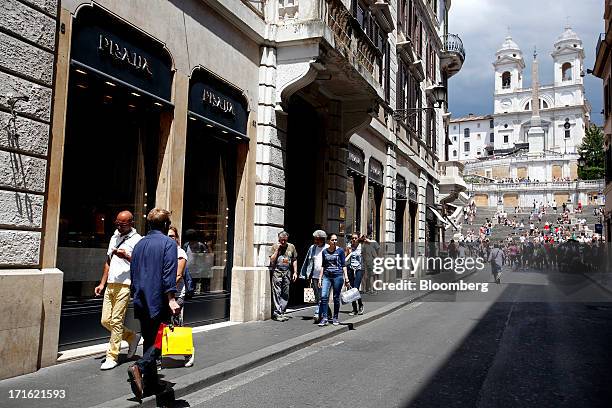 Pedestrians pass a Prada SpA store as they walk along Via Condotti near the Spanish Steps in Rome, Italy, on Wednesday, June 26, 2013. Italian...