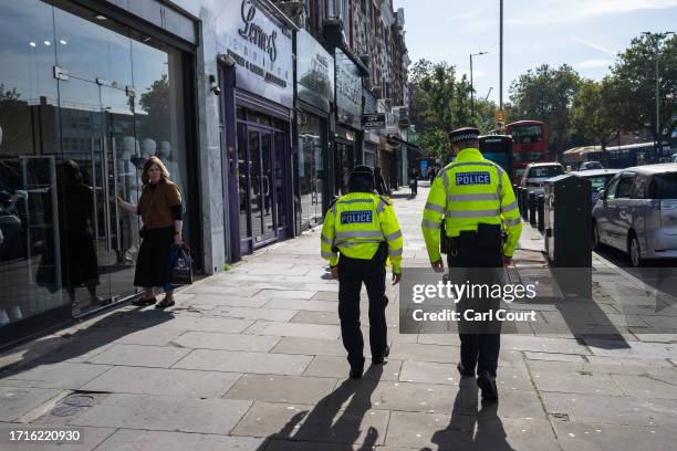 Jewish woman looks on as police officers patrol around Stamford Hill, an area of London with a large Jewish community, on October 10, 2023 in London,...