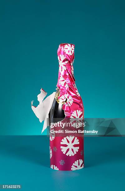 bottle of bubbly wrapped in christmas paper - bad gift stock pictures, royalty-free photos & images