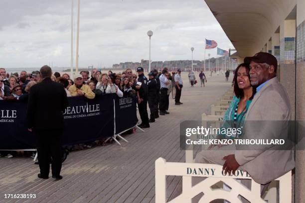 Actor Danny Glover and his wife Asake Bomani pose next to the beach closet dedicated to him on the Promenade des Planches in the French northwestern...