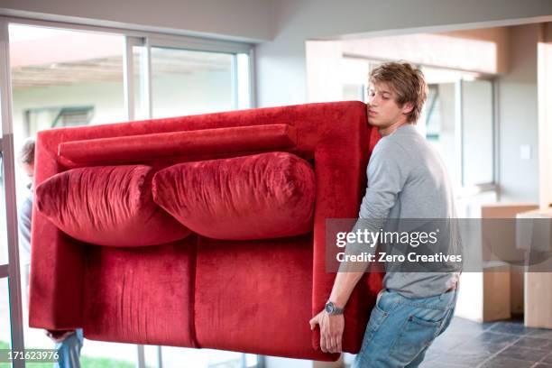 young men carrying sofa - carrying photos et images de collection