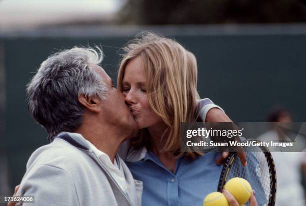 On the tennis court at La Costa Resort & Spa, American model and actress Cheryl Tiegs kisses professional tennis player Pancho Gonzales , Carlsbad,...