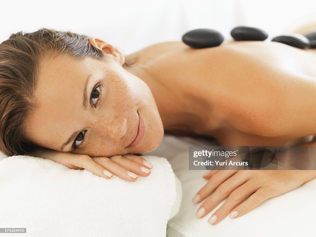 South Africa, Cape Town, Woman relaxing while getting stone massage