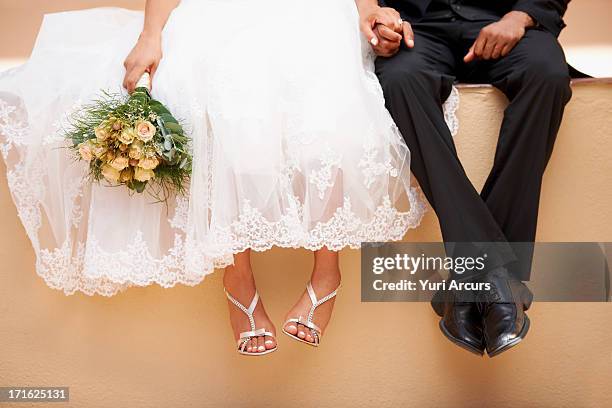 south africa, cape town, bride and groom sitting on wall - frisch verheiratet stock-fotos und bilder