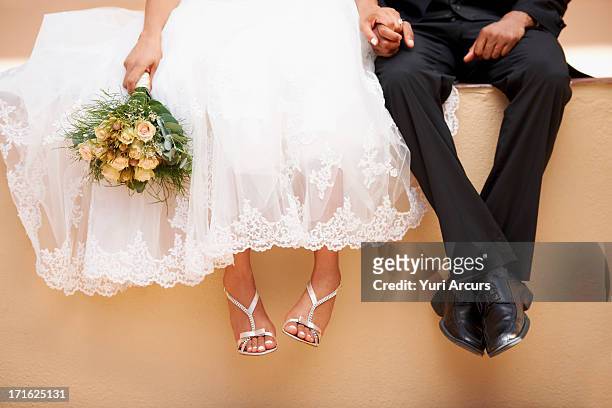 south africa, cape town, bride and groom sitting on wall - 新郎 人的角色 個照片及圖片檔