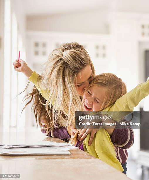 usa, utah, lehi, mother kissing daughter (6-7) during doing homework - mother child homework stock pictures, royalty-free photos & images