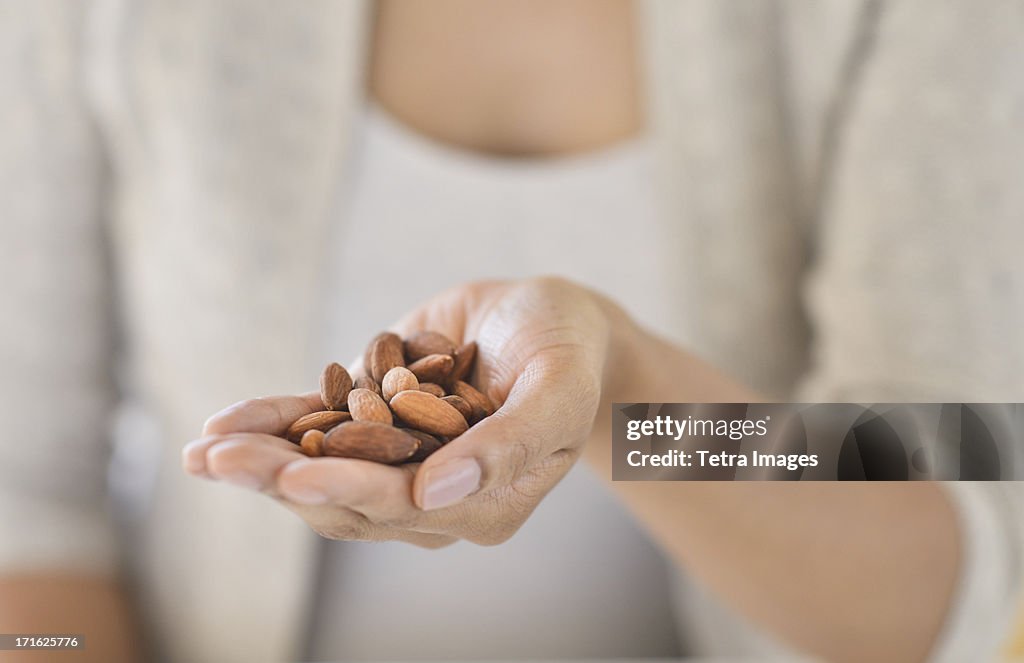 USA, New Jersey, Jersey City, Close-up of woman holding almonds