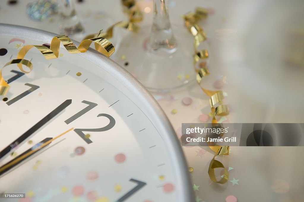12 o'clock on clock decorated with confetti and streamer