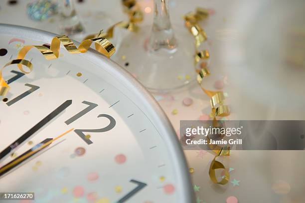 12 o'clock on clock decorated with confetti and streamer - new years eve clock stock pictures, royalty-free photos & images