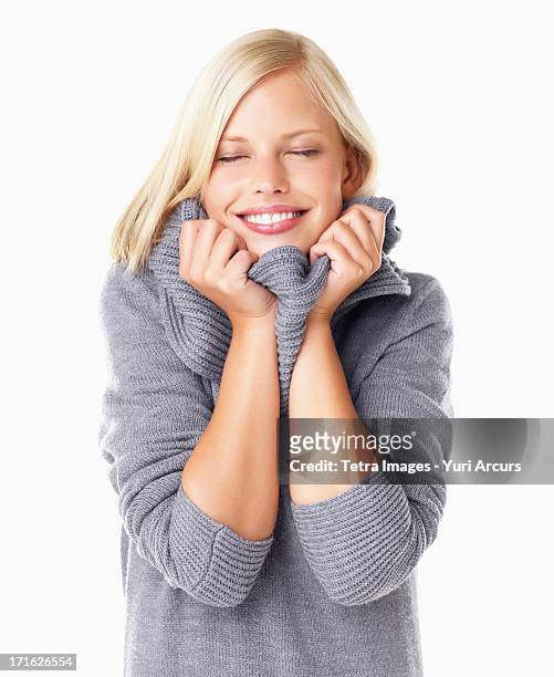 studio portrait of young woman wearing gray sweater - hot blonde woman stock-fotos und bilder