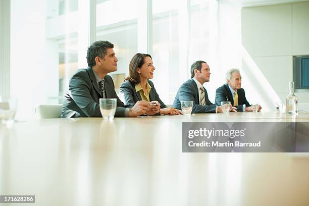 business people sitting in conference room talking - four in a row stock pictures, royalty-free photos & images