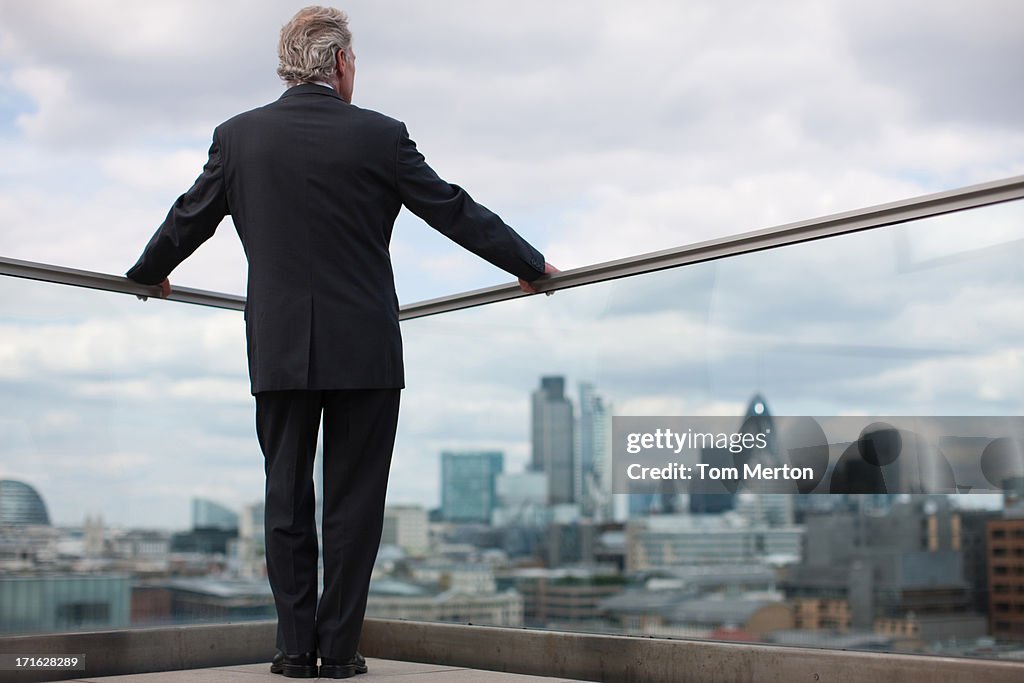 Businessman standing on urban balcony