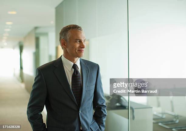 uomo d'affari a piedi lungo il corridoio di un ufficio moderno - chief executive officer foto e immagini stock