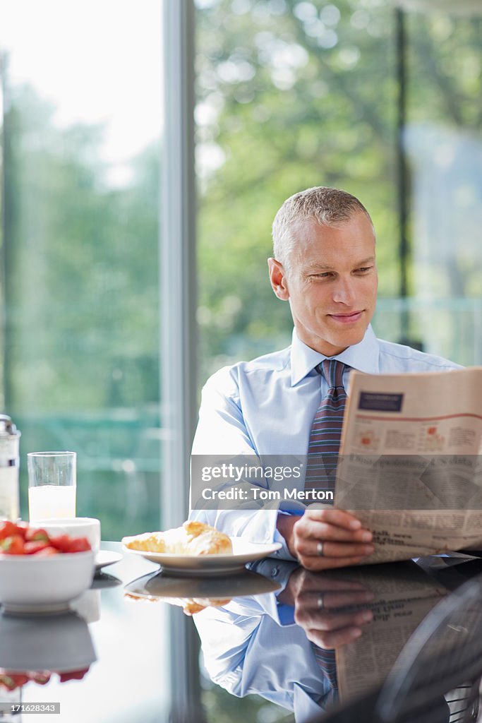 Businessman reading newspaper in morning