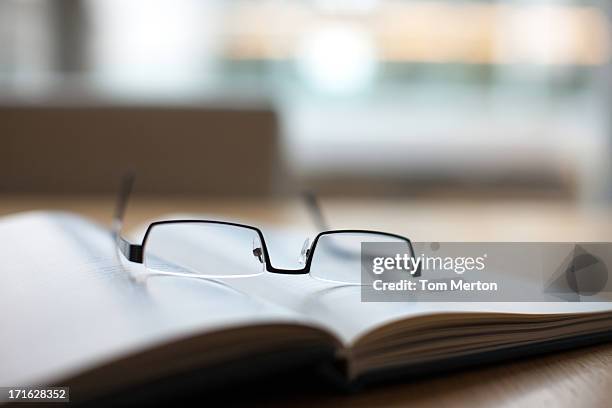 eyeglasses and book on conference table - office still life stock pictures, royalty-free photos & images