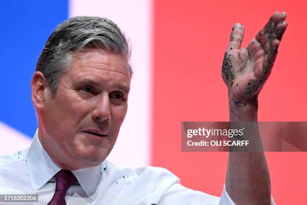 Britain's main opposition Labour Party leader Keir Starmer gestures with his hand covered in glitter that was thrown by a protester during his...