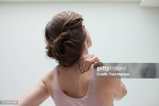 woman rubbing aching back - shoulder stock pictures, royalty-free photos & images