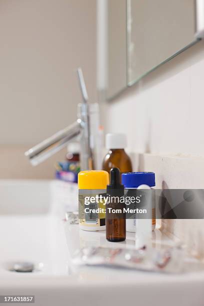 toiletries and medication on sink in bathroom - bathroom medicine cabinet stock pictures, royalty-free photos & images