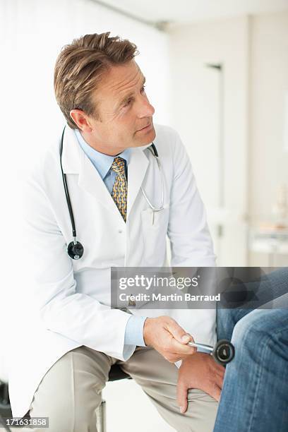 doctor checking patients reflexes in doctors office - reflex hammer stock pictures, royalty-free photos & images