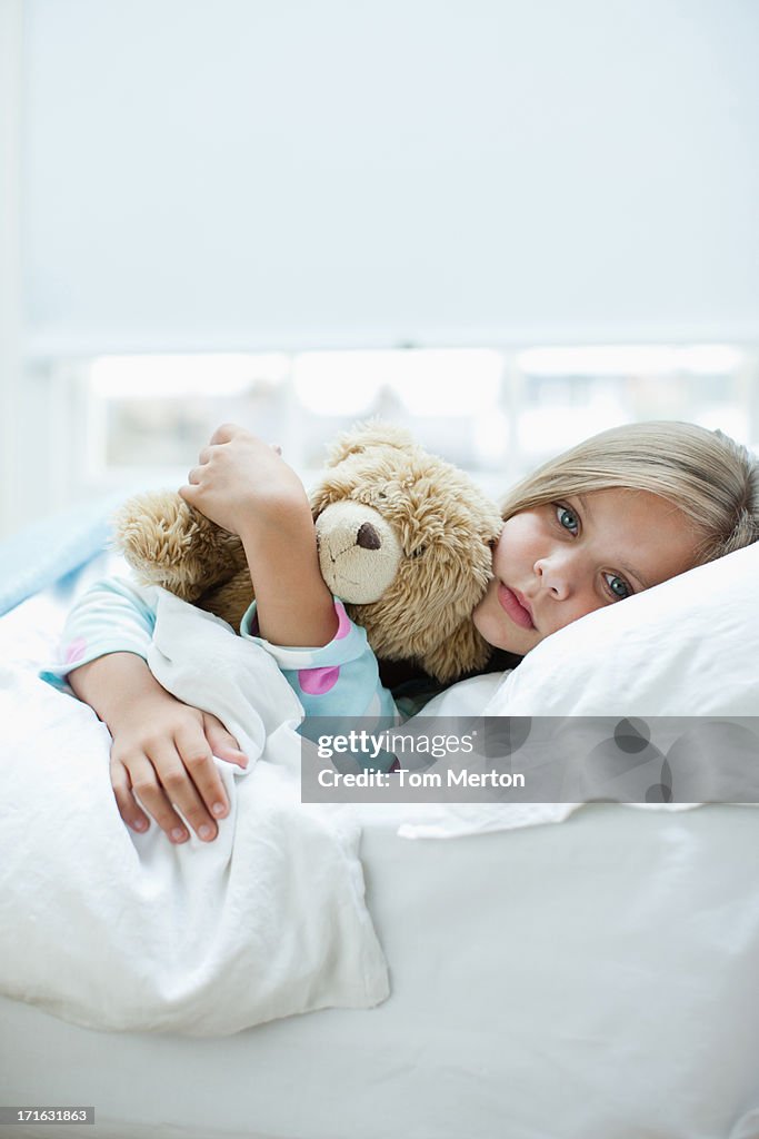 Enjoado Menina pôr na cama com Urso de Pelúcia