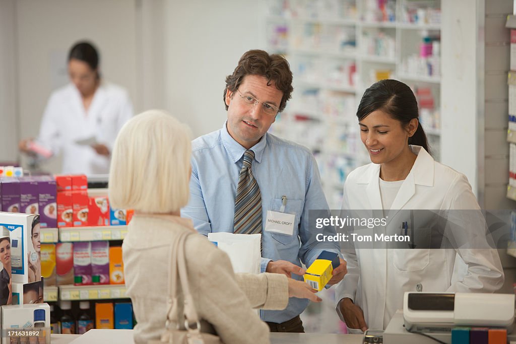 Pharmacists answering questions for customer in drug store