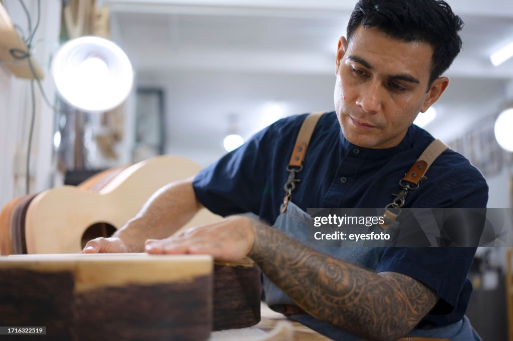 Gitarrenbauer baut Gitarre in der Werkstatt.
