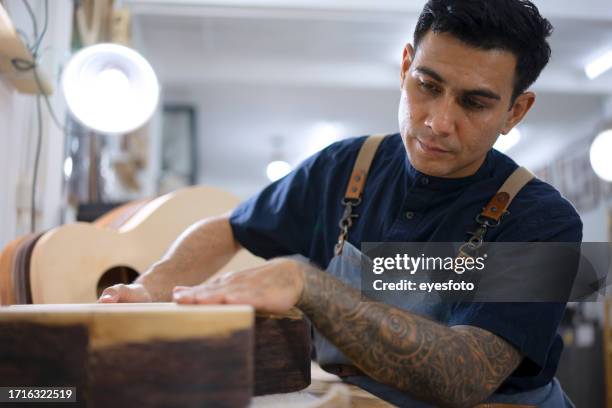 gitarrenbauer baut gitarre in der werkstatt. - darstellender künstler stock-fotos und bilder
