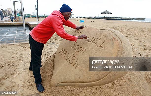 Sand sculptor is seen doing his bit for the former ailing South African President Nelson Mandela on June 27, 2013 at the South Beach in Durban.Nelson...