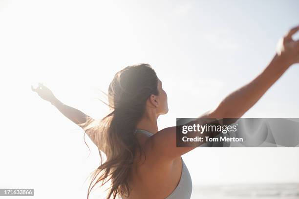 woman standing with arms outstretched on beach - hair back bildbanksfoton och bilder