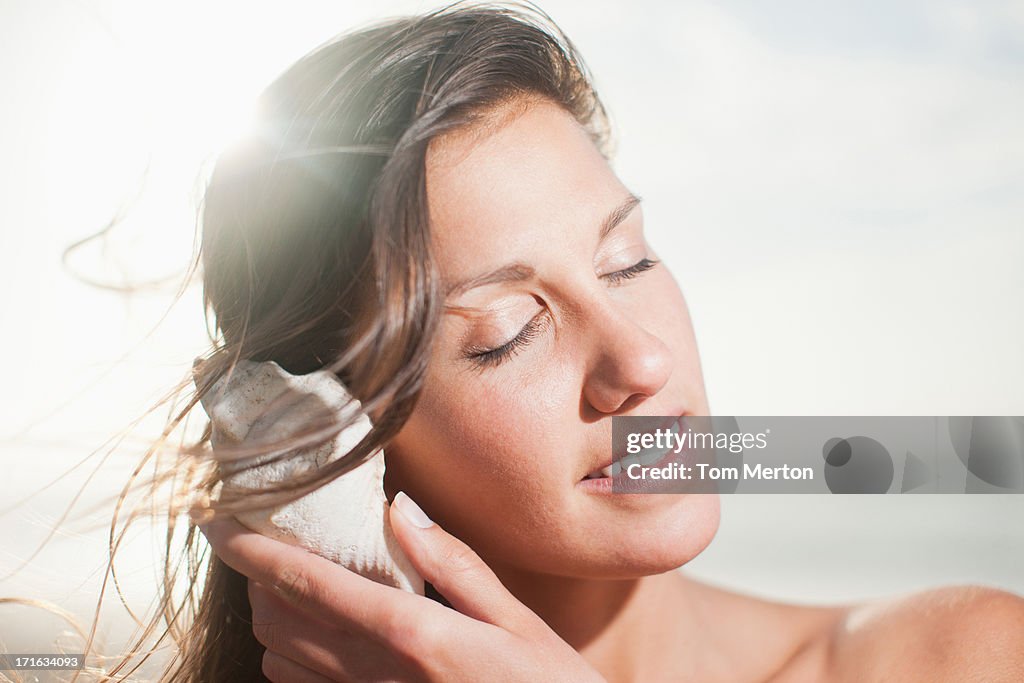 Plano aproximado de mulher ouvir Concha do mar