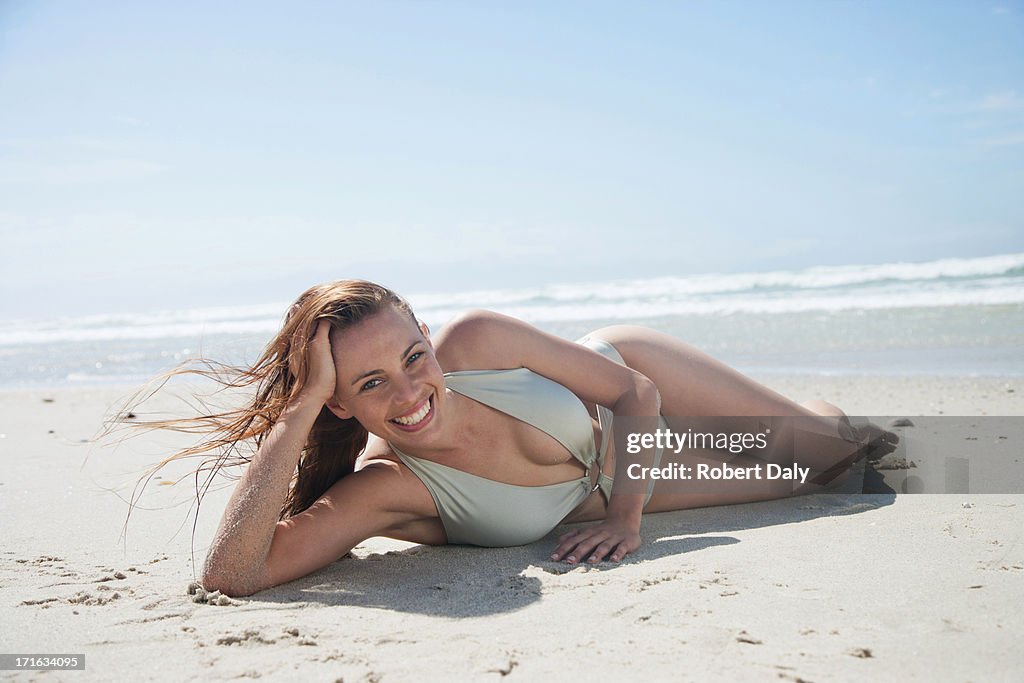 Woman in bathing suit laying on beach