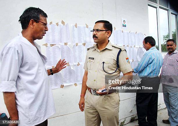 Man talking to SP City Jagdish Chandra about his missing relatives at Doon Helidrome on June 27, 2013 in Dehradun, India. More than 100,000 mainly...