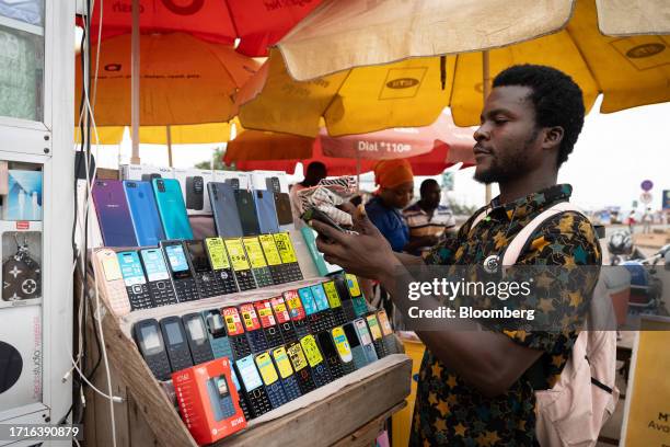 Mobile phone vendor arranges his display on a stall at a market in Accra, Ghana on Tuesday, Oct. 10, 2023. Ghana is scheduled to release consumer...