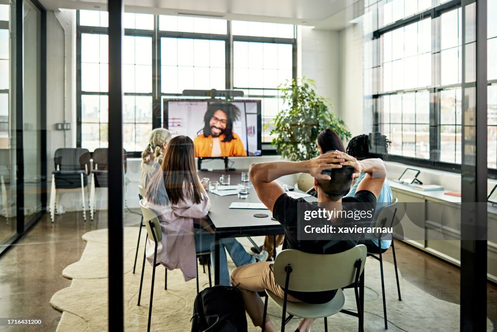 Reunión de negocios relajada fotografiada a través de la ventana