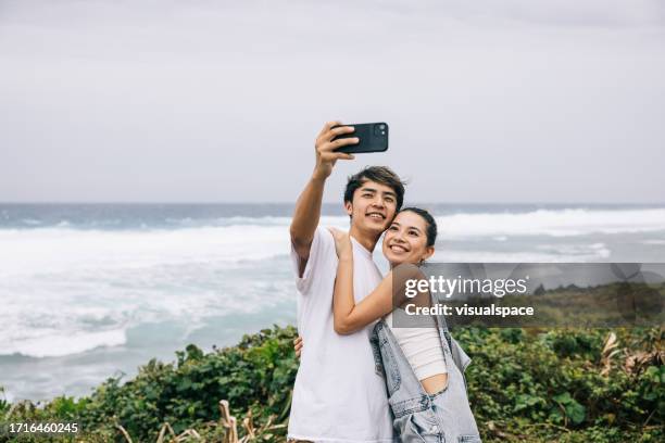 japanese couple taking a selfie with the view - japanese ethnicity stock pictures, royalty-free photos & images